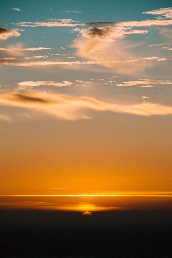 Sunset with clouds and ocean horizon.