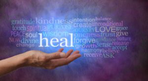 Hand with healing-related words on colorful background.